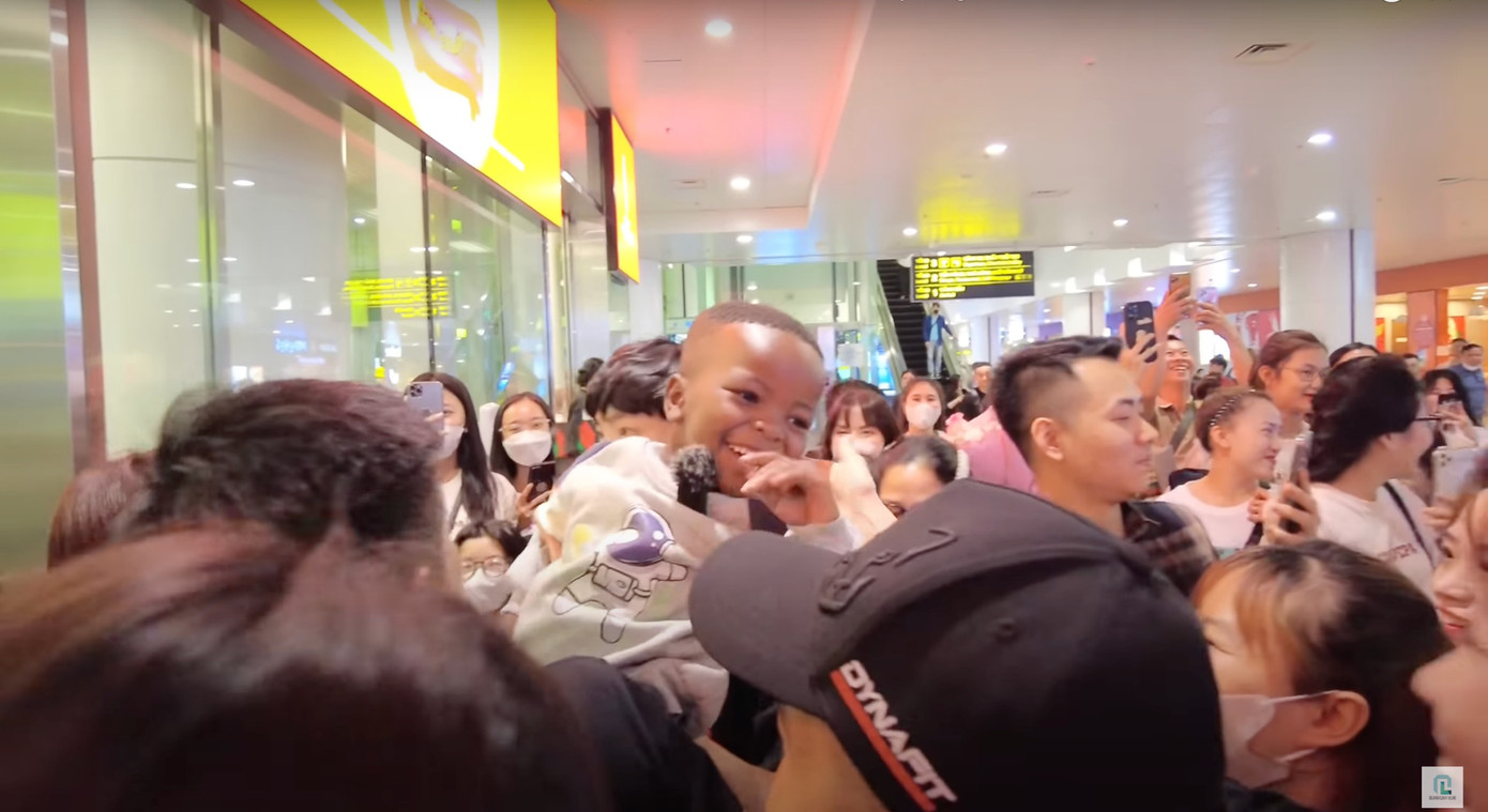 Cậu bé được người hâm mộ chào đón nhiệt tình tại sân bay. Ảnh: Quang Linh Vlogs.