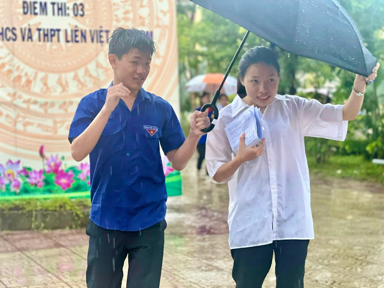 Một thanh niên tình nguyện che ô cho thí sinh tại Kỳ thi Tốt nghiệp THPT năm ngoái. (ảnh: Thái Lâm). Một thanh niên tình nguyện che ô cho thí sinh tại Kỳ thi Tốt nghiệp THPT năm ngoái. (ảnh: Thái Lâm).