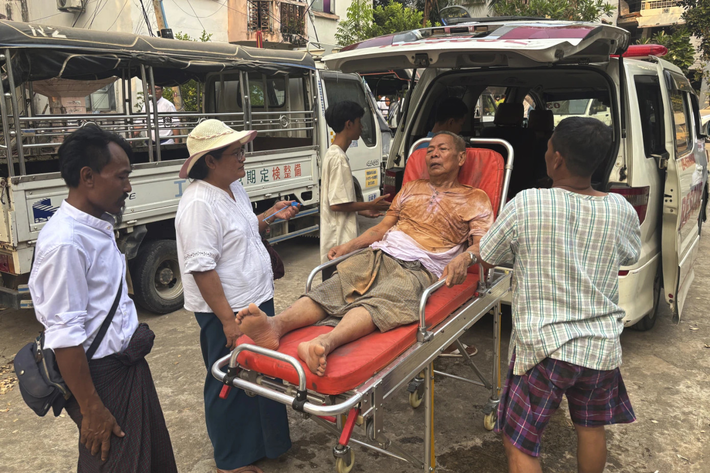 Các nhân viên cứu hộ đưa một người đàn ông mắc kẹt dưới một toà nhà đi cấp cứu tại Naypyitaw, Myanmar. Ảnh: AP.