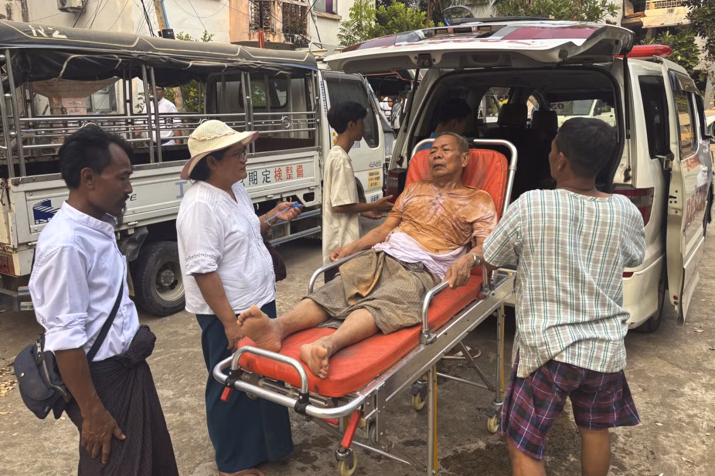 Các nhân viên cứu hộ đưa một người đàn ông mắc kẹt dưới một toà nhà đi cấp cứu tại Naypyitaw, Myanmar. Ảnh: AP.