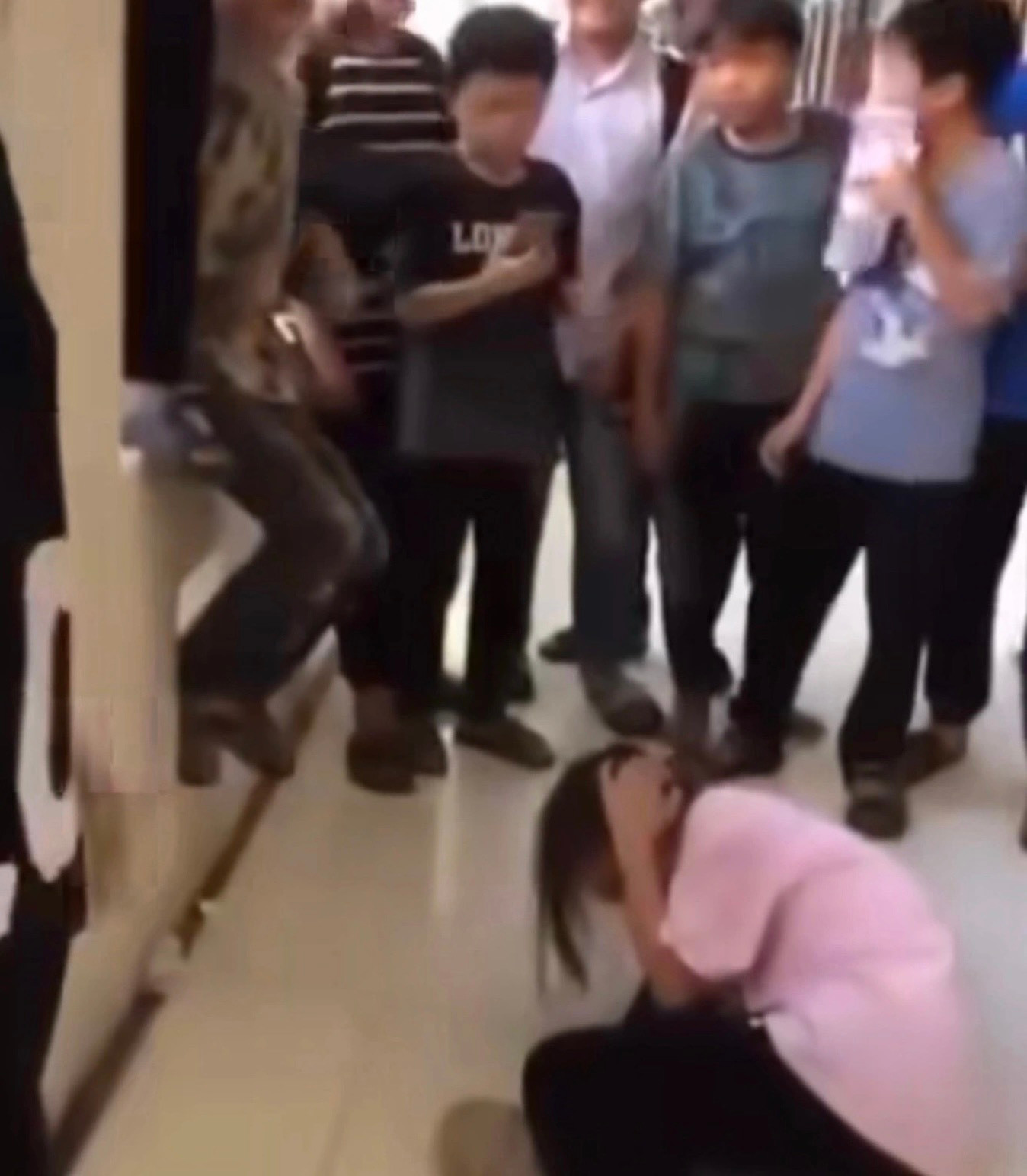 Trong khi nhóm người đang hành hung nữ sinh, xung quanh có các học sinh khác đứng xem và quay video. (ảnh cắt từ video) Trong khi nhóm người đang hành hung nữ sinh, xung quanh có các học sinh khác đứng xem và quay video. (ảnh cắt từ video)
