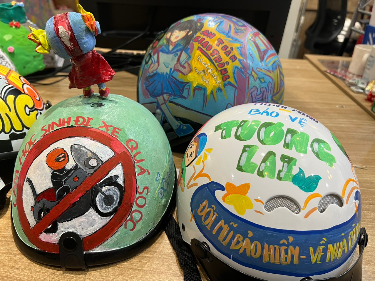 Học sinh thiết kế những mẫu mũ bảo hiểm với slogan: "Đầu trần chạy ẩu, thoáng nhìn thật ngầu. Đụng xe té ngã, ngầu không thấy đâu". Hay "Đội mũ bảo hiểm, về nhà bình an"; "Đội mũ lên"...