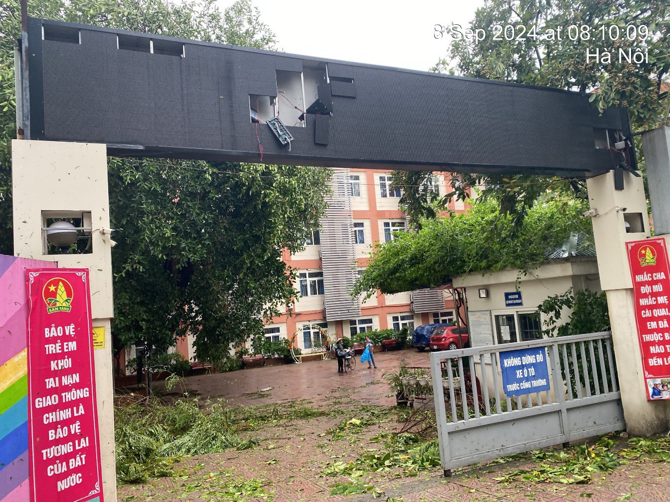 Cổng trường THCS Ba Đình, quận Ba Đình (Hà Nội) bị gió quật gây hỏng hóc, sân trường ngổn ngang cành cây bị gãy. Nhiều biển hiệu trong trường đổ gục xuống, đè lên các cây trong khuôn viên.