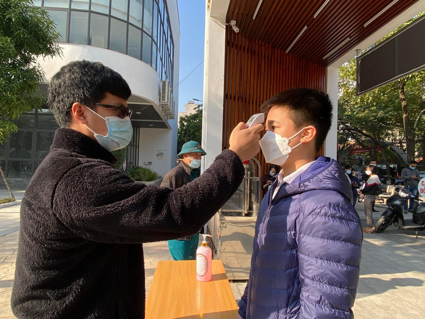 Học sinh được đo nhiệt độ trước khi vào điểm tiêm. Học sinh được đo nhiệt độ trước khi vào điểm tiêm.