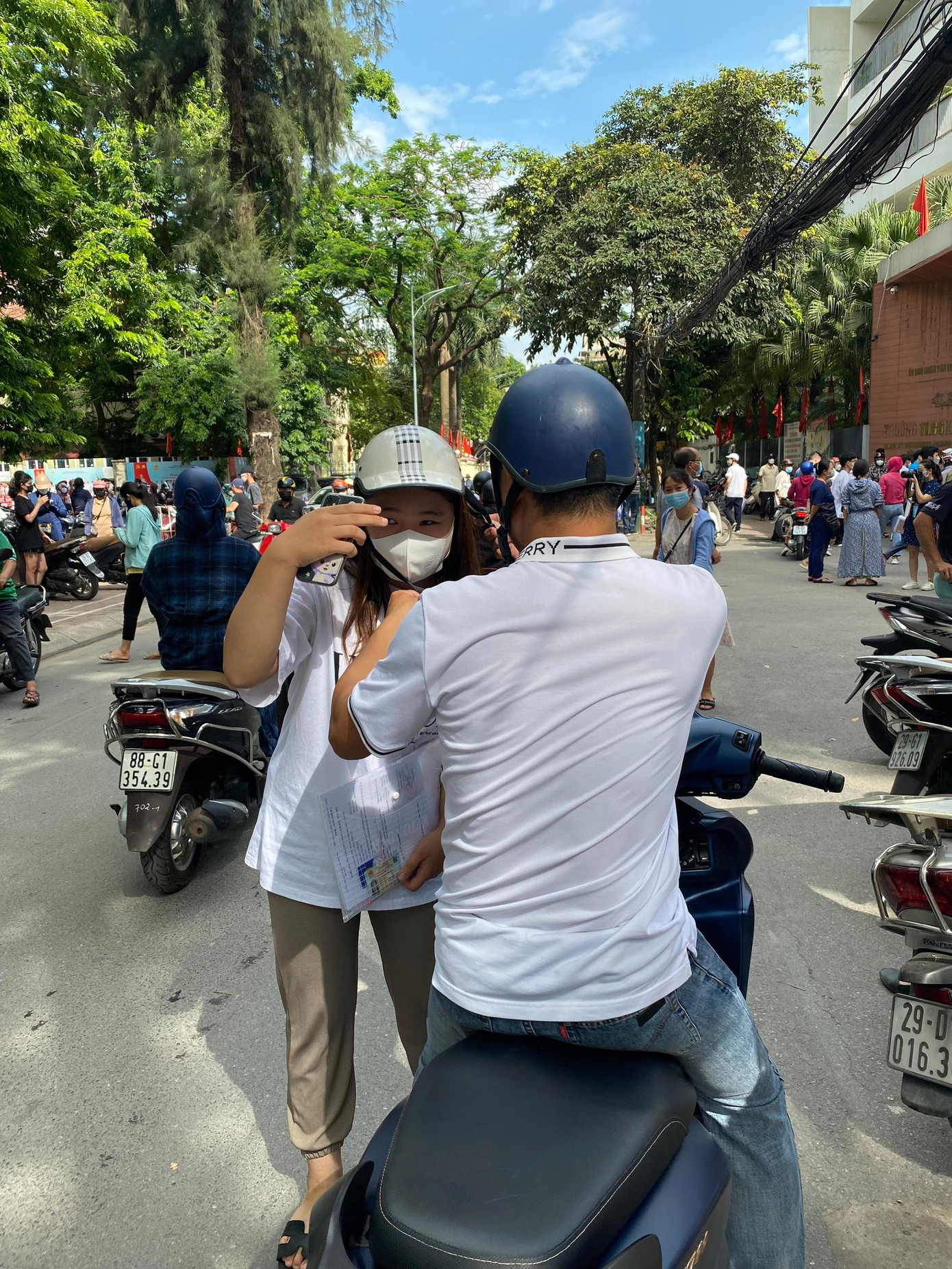 Khác với ông bố ân cần cởi mũ bảo hiểm cho con trước khi vào phòng thi, nhiều phụ huynh chở con tham gia giao thông bằng xe máy nhưng không đội mũ bảo hiểm. (ảnh: Hà Linh) Khác với ông bố ân cần cởi mũ bảo hiểm cho con trước khi vào phòng thi, nhiều phụ huynh chở con tham gia giao thông bằng xe máy nhưng không đội mũ bảo hiểm. (ảnh: Hà Linh)