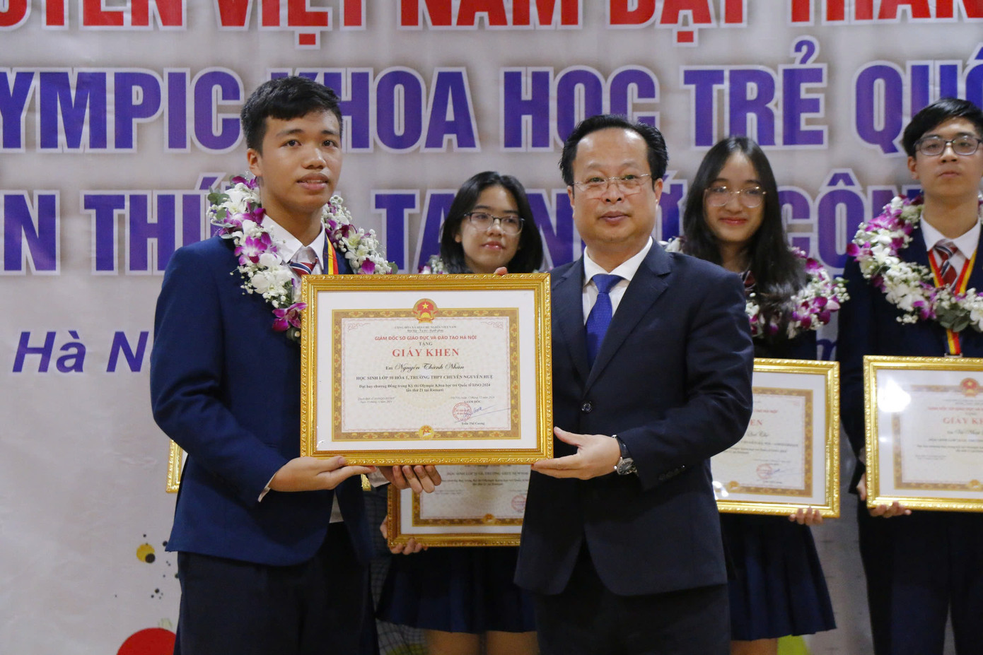 Giám đốc Sở GD&amp;ĐT Hà Nội tặng Giấy khen, tặng hoa và chúc mừng, động viên học sinh tại sân bay Nội Bài.