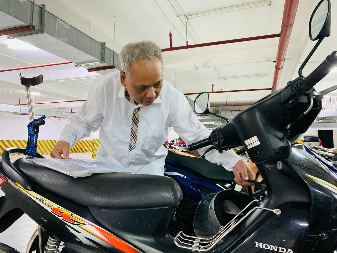 Buộc chặt cây nạng phía sau xe, túi đựng đồ cá nhân phía trước ông cụ vui vẻ rời điểm thi. Buộc chặt cây nạng phía sau xe, túi đựng đồ cá nhân phía trước ông cụ vui vẻ rời điểm thi.