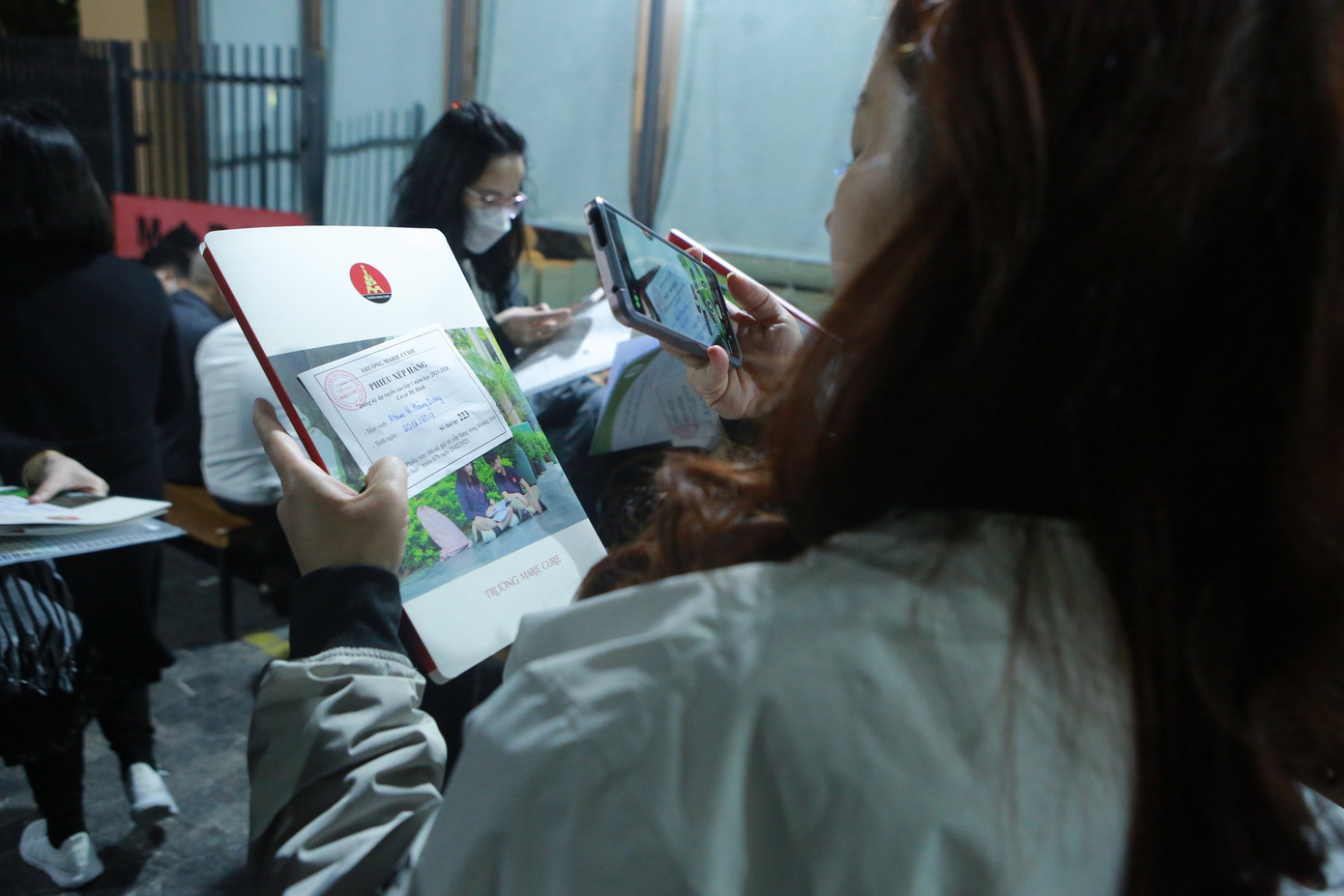 Phụ huynh xếp hàng để mua hồ sơ cho con vào lớp 1 ở Trường Marie Curie. (Trọng Tài)