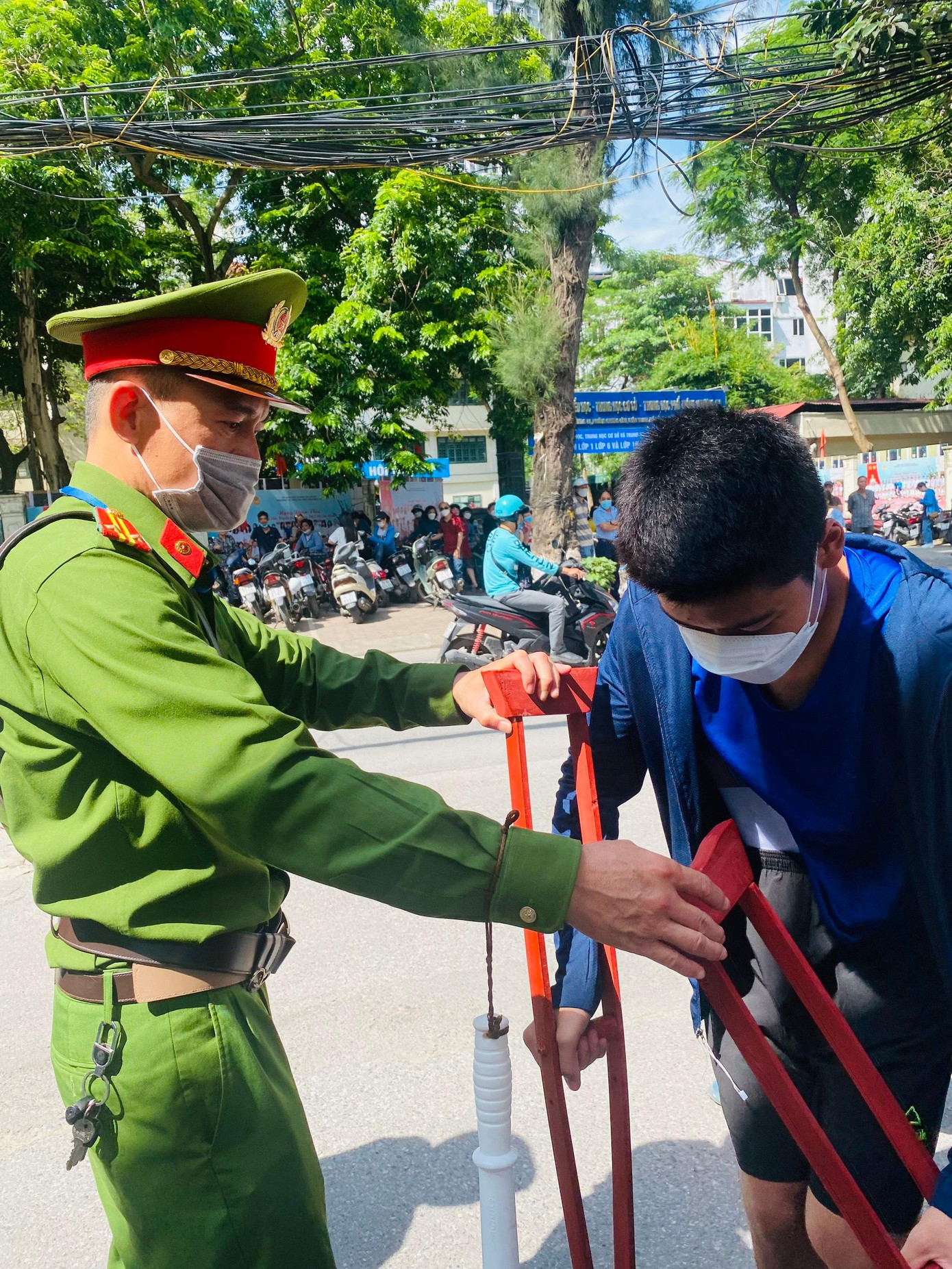 Từ ngoài cổng điểm thi, thí sinh được lực lượng công an hỗ trợ. Thí sinh bị đau chân, không mặc được quần dài. Từ ngoài cổng điểm thi, thí sinh được lực lượng công an hỗ trợ. Thí sinh bị đau chân, không mặc được quần dài.