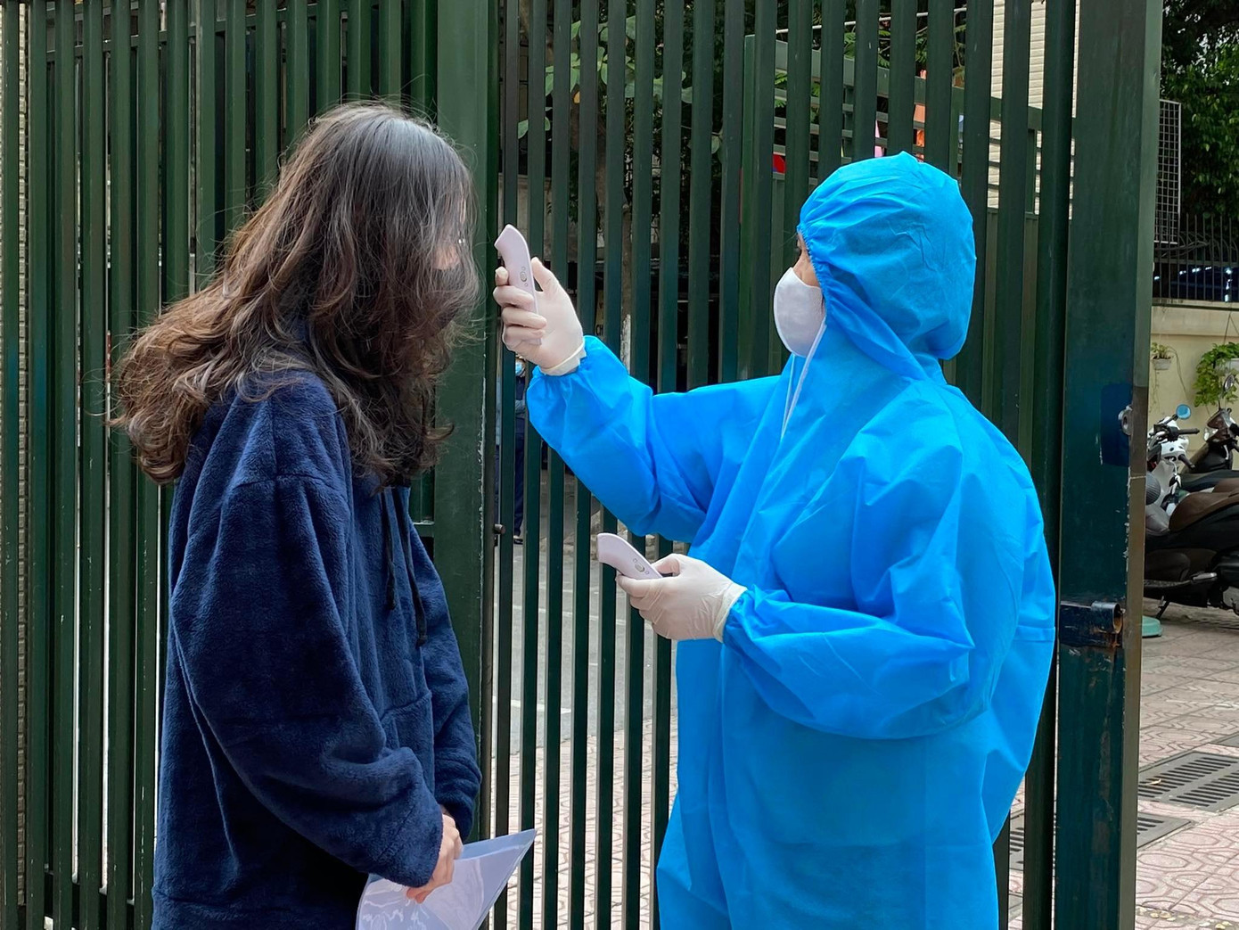 Tại Trường THPT Kim Liên, quận Đống Đa (Hà Nội), học sinh được đo nhiệt độ từ ngoài cổng trường. Nếu có trường hợp nhiệt độ cao, các em được đưa đi theo lối riêng về phòng cách ly chờ kiểm tra y tế.