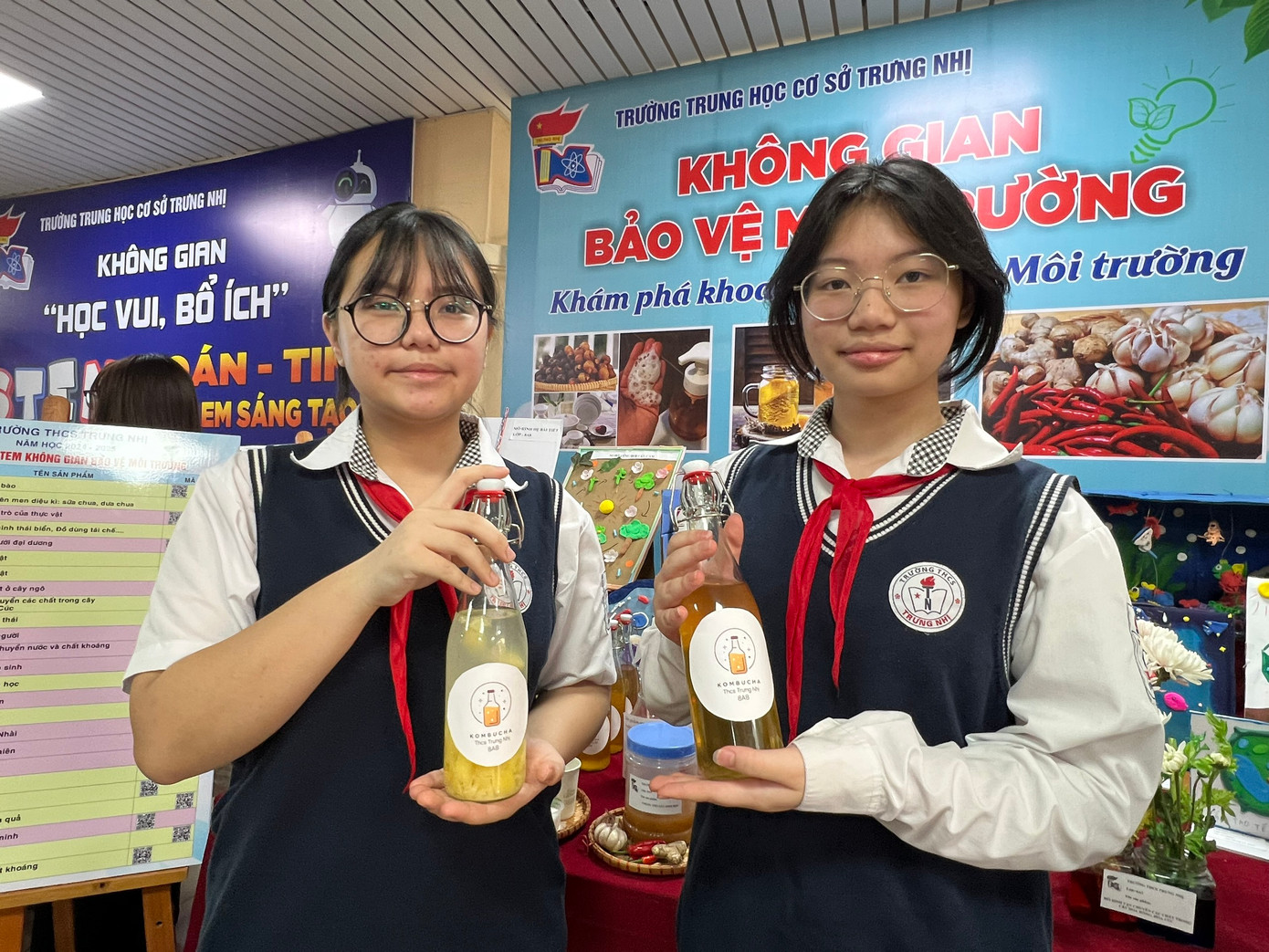 Đỗ Bảo Yến và Trần Minh Ngọc giới thiệu trà kompucha từ hoa nhài sấy khô cho thầy cô, phụ huynh. Đỗ Bảo Yến và Trần Minh Ngọc giới thiệu trà kompucha từ hoa nhài sấy khô cho thầy cô, phụ huynh.