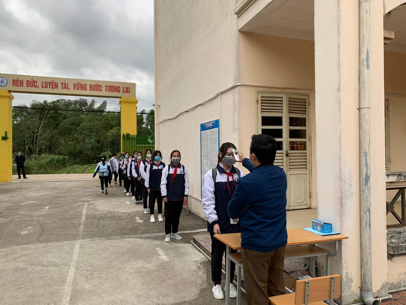 Học sinh được đo nhiệt độ trước khi vào lớp.