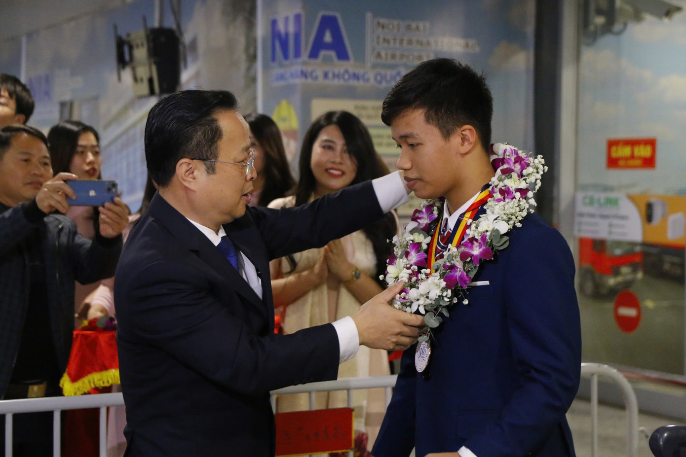 Giám đốc Sở GD&amp;ĐT Hà Nội tặng Giấy khen, tặng hoa và chúc mừng, động viên học sinh tại sân bay Nội Bài.