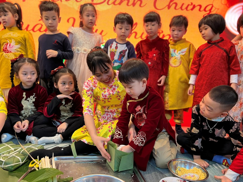 Cô giáo hướng dẫn học sinh gói bánh chưng. Cô giáo hướng dẫn học sinh gói bánh chưng.