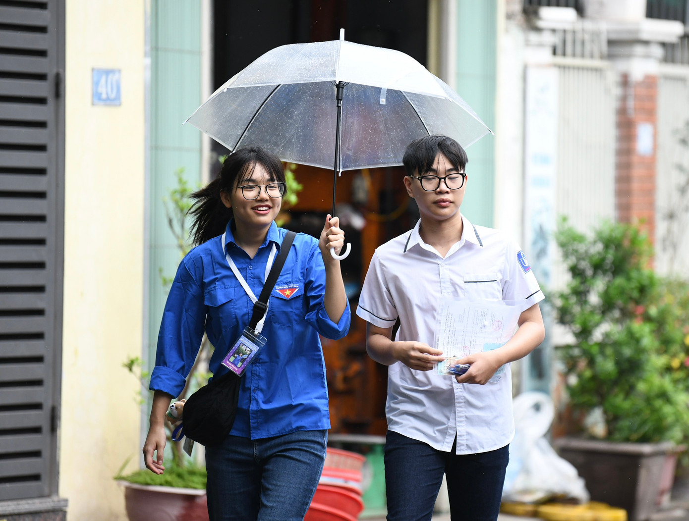 Một thanh niên tình nguyện che ô cho thí sinh tại điểm thi THPT Khương Đình. Một thanh niên tình nguyện che ô cho thí sinh tại điểm thi THPT Khương Đình.