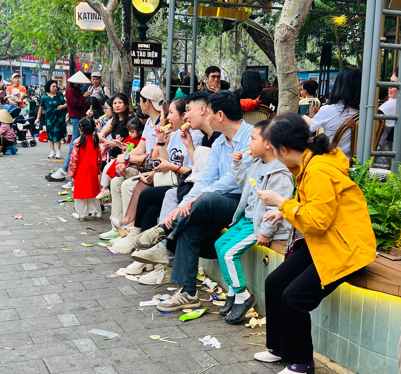 Người dân ăn kem, nghỉ ngơi với "núi rác nhỏ" ngay dưới chân.