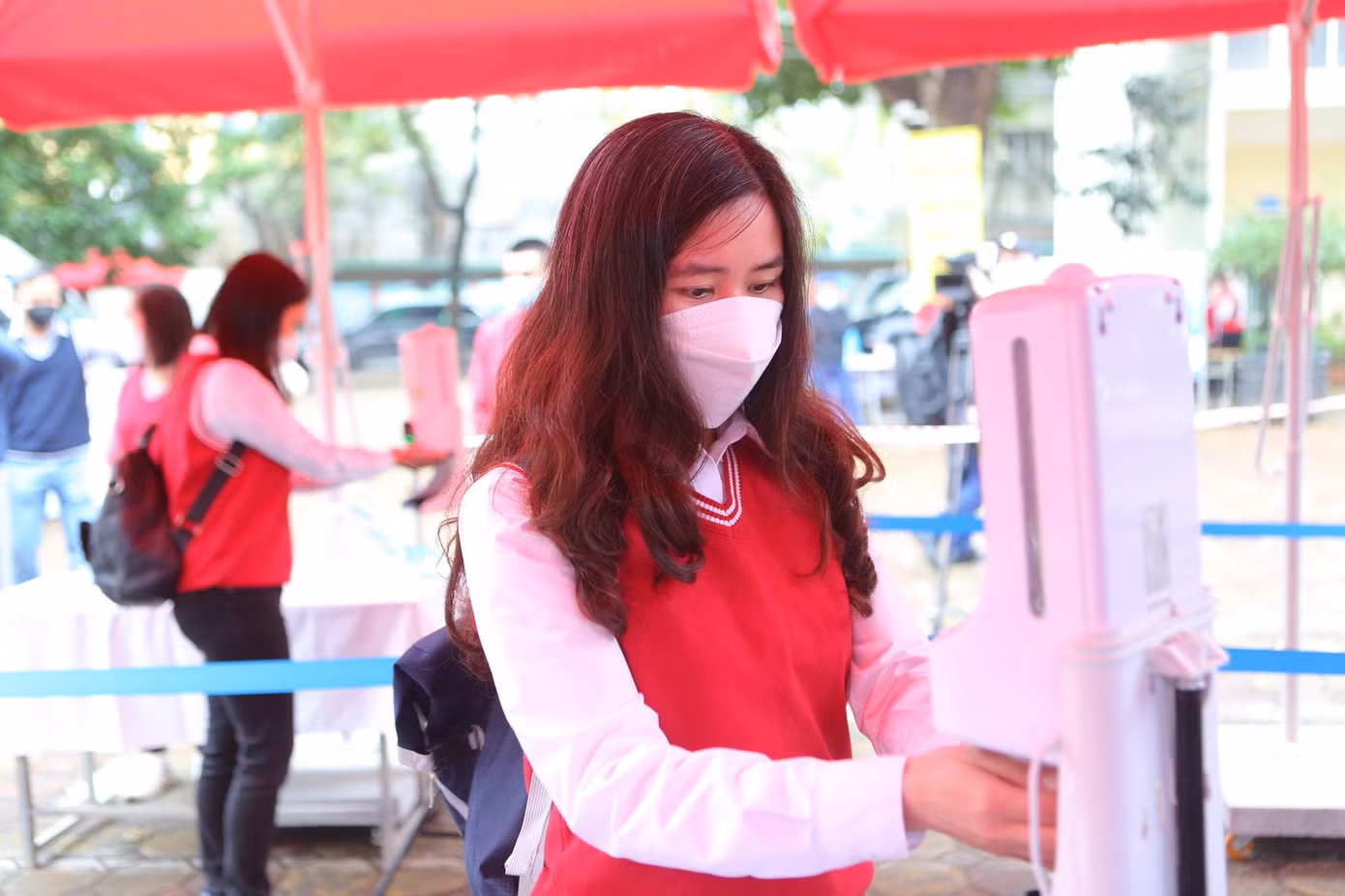 Học sinh được đo thân nhiệt, sát khuẩn trước khi vào lớp.