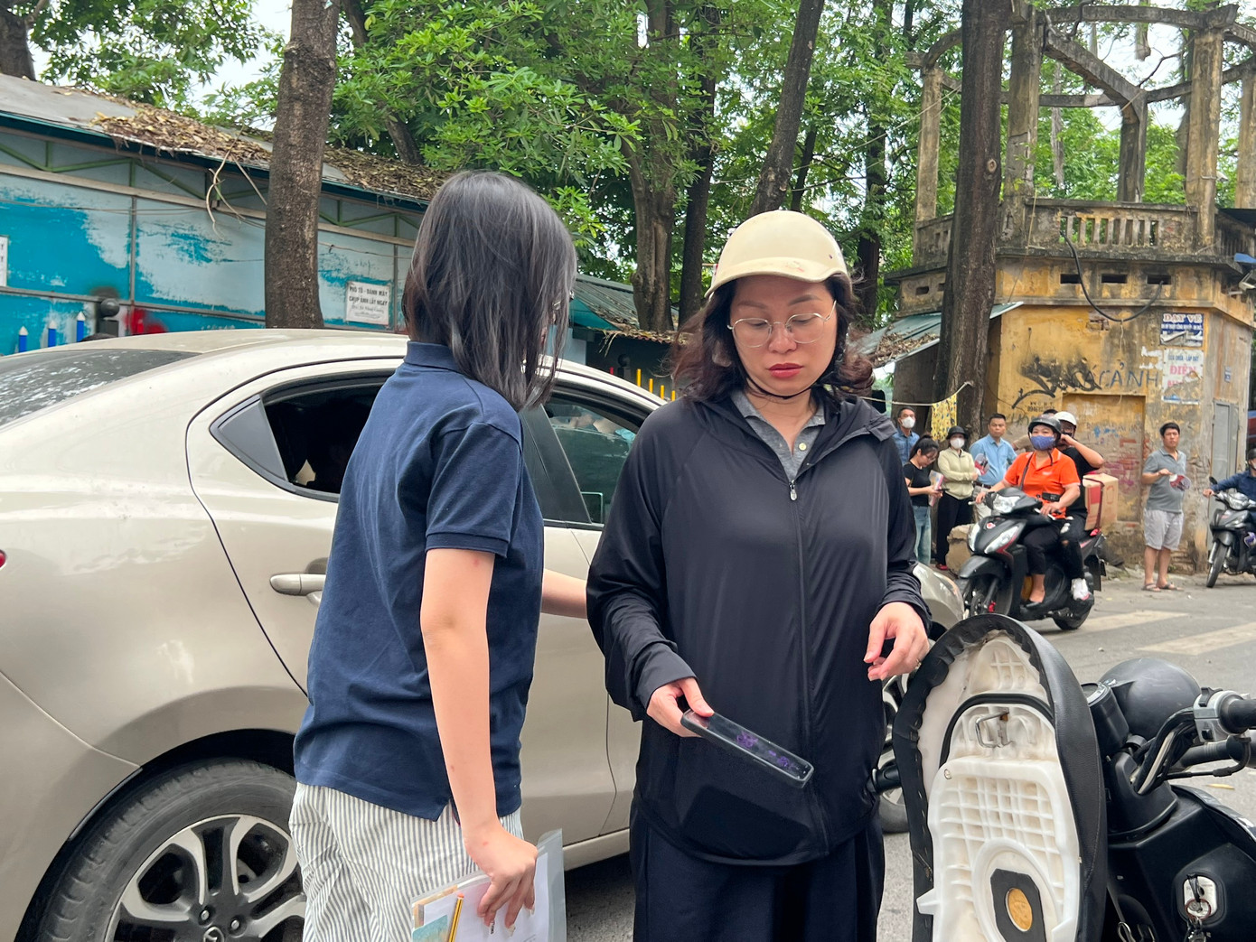 Một thí sinh cẩn thận gửi điện thoại cho phụ huynh trước khi vào điểm thi tại Hà Nội. (ảnh; Nguyễn Hà)