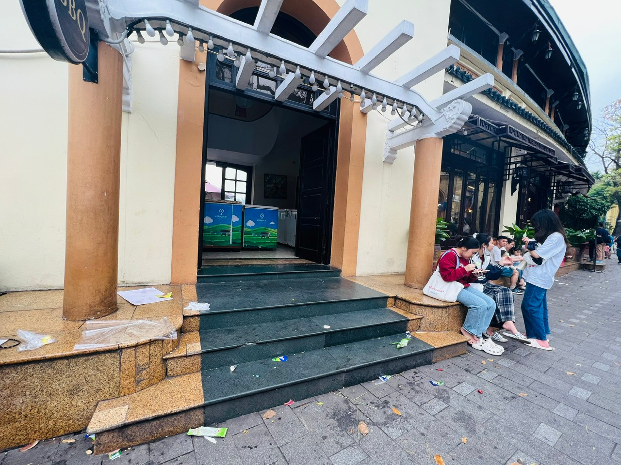 Bậc thềm của nhà hàng ngổn ngang túi ni lông, giấy lót, vỏ kem vương vãi.