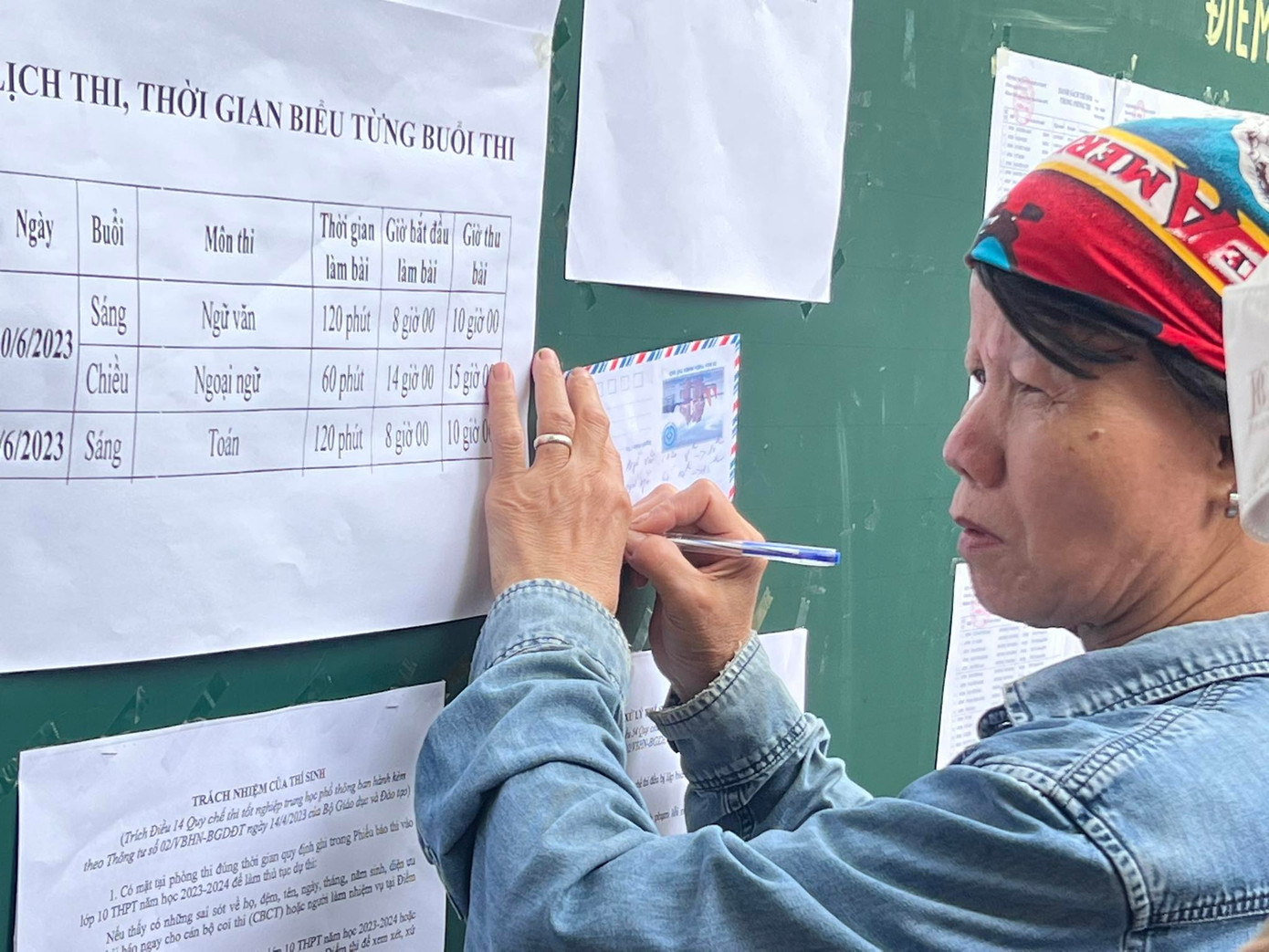 Một phụ huynh cẩn thận ghi lại lịch thi để nhắc nhở con. Một phụ huynh cẩn thận ghi lại lịch thi để nhắc nhở con.