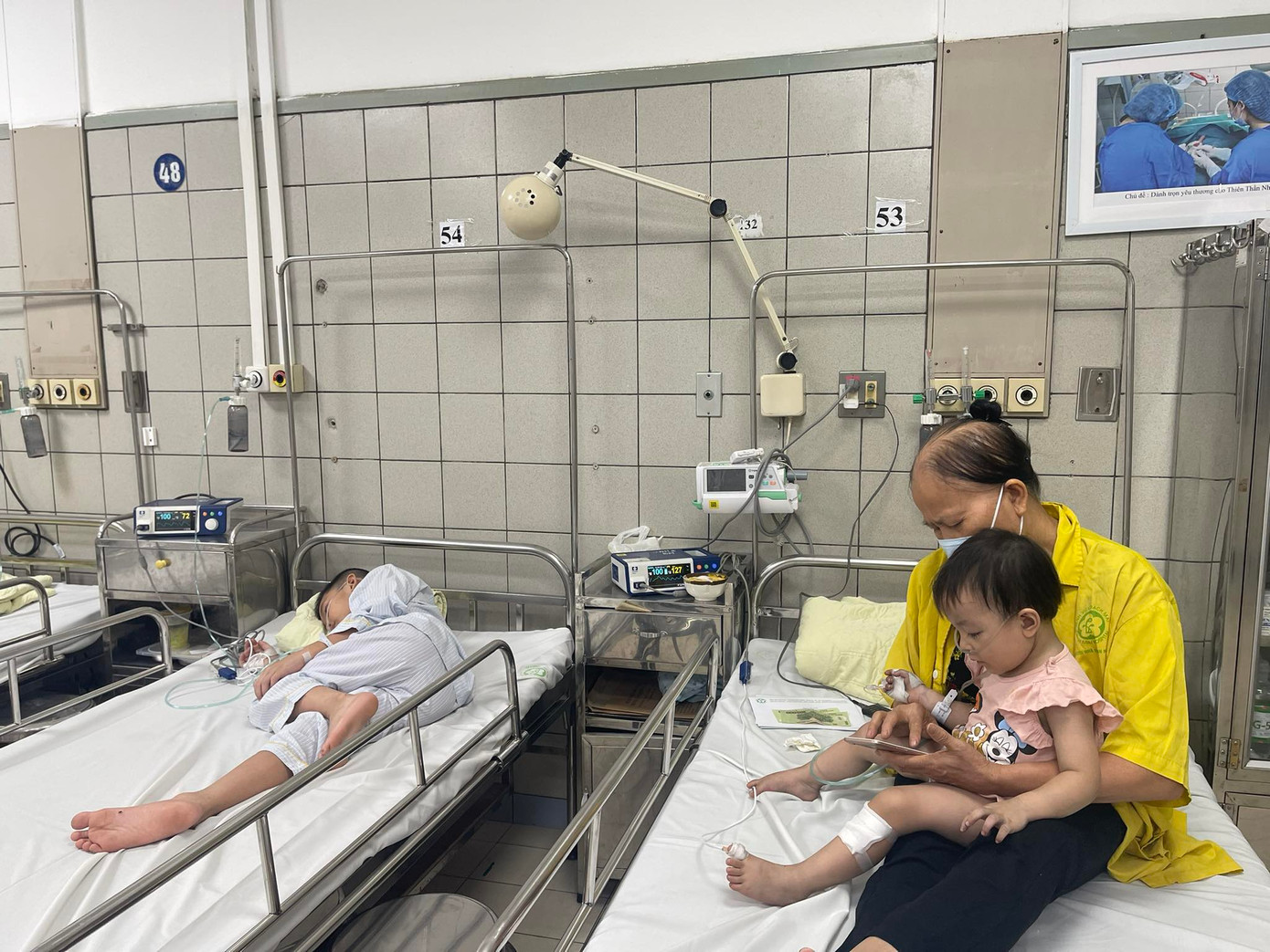 Một học sinh và một em bé nạn nhân của vụ cháy đang điều trị tại Bệnh viện Bạch Mai (ảnh: Hà Minh)