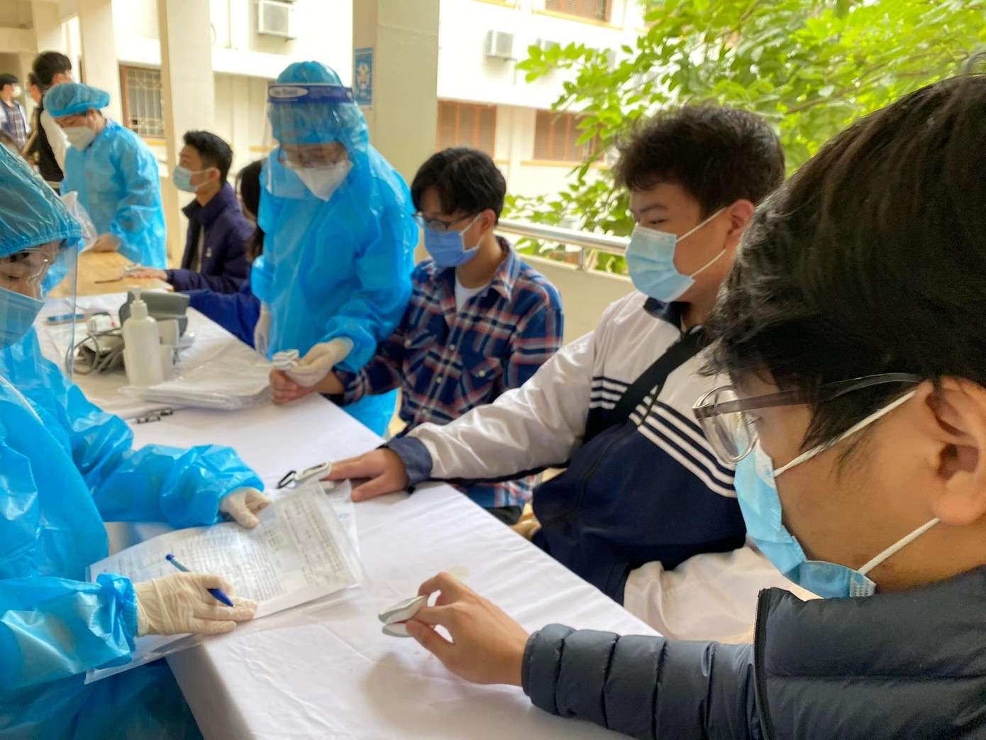 Học sinh được kiểm tra sức khoẻ cẩn thận trước khi tiêm. Để đảm bảo an toàn cho công tác phòng dịch, nhà trường bố trí mỗi khung giờ chỉ có 2 lớp đến tiêm.