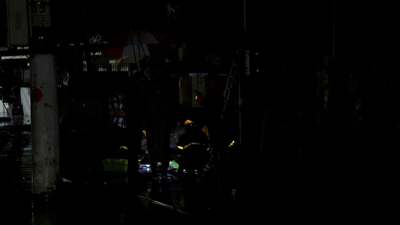 Các cán bộ lắp đặt trạm phát sóng trong điều kiện trời mưa, đêm tối.