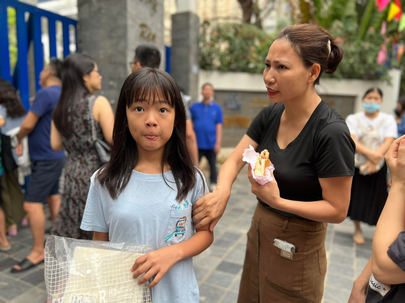 Học sinh ăn vội bữa sáng trước giờ vào phòng thực hiện các bài kiểm tra, đánh giá năng lực.