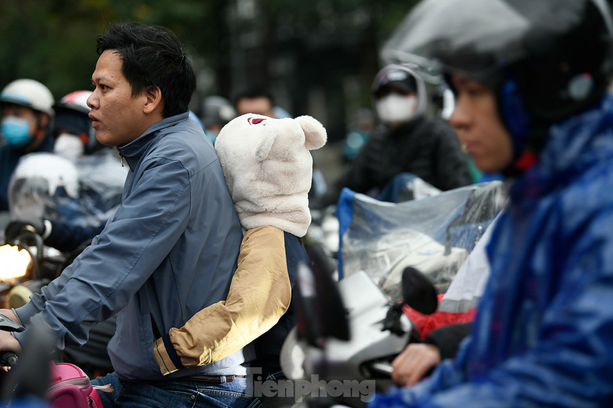 Học sinh trùm kín mít được người thân đưa đến trường trong sáng 22/1. Ảnh: Như Ý Học sinh trùm kín mít được người thân đưa đến trường trong sáng 22/1. Ảnh: Như Ý