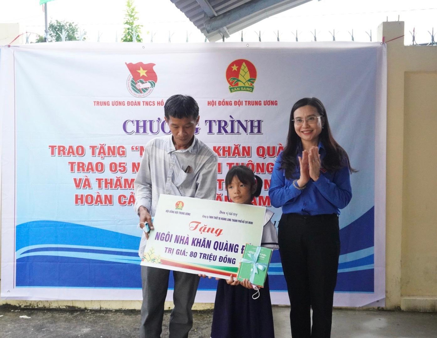 Chị Nguyễn Phạm Duy Trang, Bí thư T.Ư Đoàn, Chủ tịch Hội đồng Đội T.Ư (bên phải) trao kinh phí hỗ trợ xây dựng “Ngôi nhà Khăn Quàng Đỏ” cho gia đình em Anh Thư, tại Vũng Liêm, Vĩnh Long