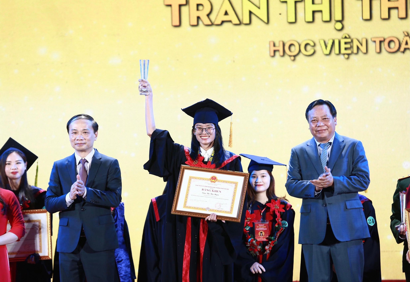 Ông Phạm Tất Thắng, Phó Trưởng ban thường trực Ban Dân vận T.Ư (bên trái) và ông Nguyễn Văn Phong, Phó Bí thư Thành ủy Hà Nội trao phần thưởng cho thủ khoa xuất sắc. Ảnh: Bảo Anh