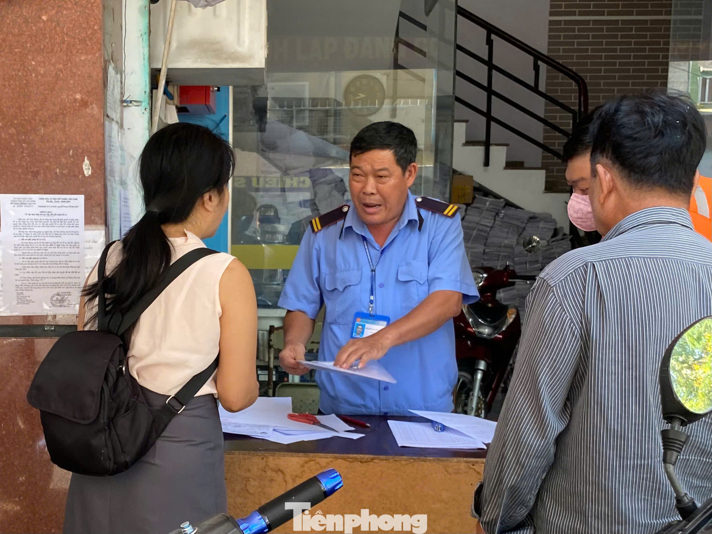 Lực lượng bảo vệ hướng dẫn người dân làm thủ tục cấp đổi GPLX. Ảnh: Hữu Huy