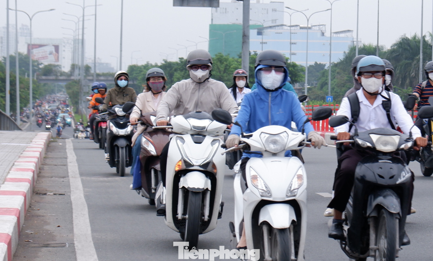Sáng 24/2, TPHCM se lạnh, người dân đeo khẩu trang, khoác thêm áo ấm khi ra đường. Ảnh: Hữu Huy