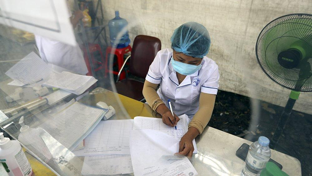 Cán bộ kiểm dịch ghi lại lịch trình của người dân khi lưu thông qua chốt kiểm dịch. Ảnh: Mạnh Thắng