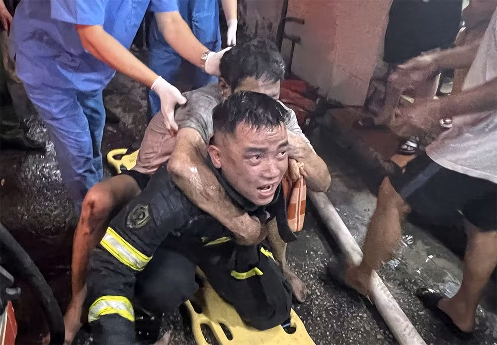 Thượng úy Nguyễn Viết Quân cõng nạn nhân mắc kẹt trong vụ cháy nhà xuống dưới. Ảnh: NVCC Thượng úy Nguyễn Viết Quân cõng nạn nhân mắc kẹt trong vụ cháy nhà xuống dưới. Ảnh: NVCC