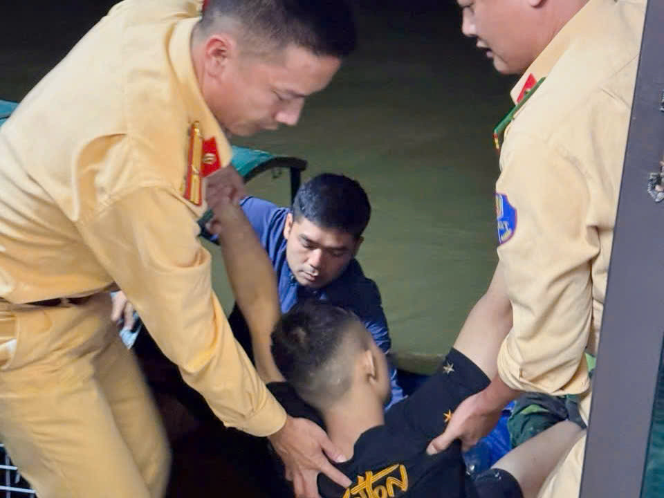 Tổ công tác cùng người dân đưa nam thanh niên lên cano sơ cứu.