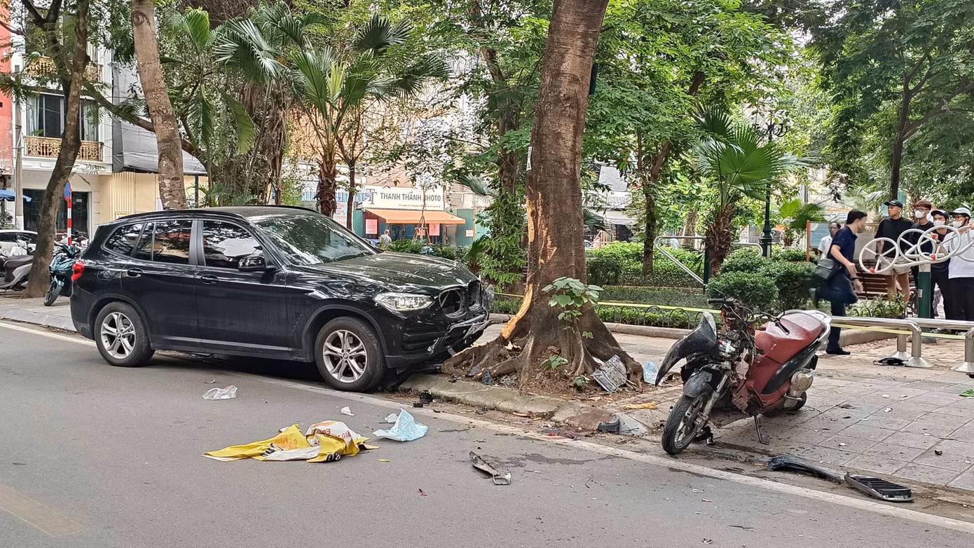 Chiếc ô tô hạng sang hiệu BMW và xe máy SH bị hư hỏng nặng phần đầu. (Ảnh: Thanh Hà)