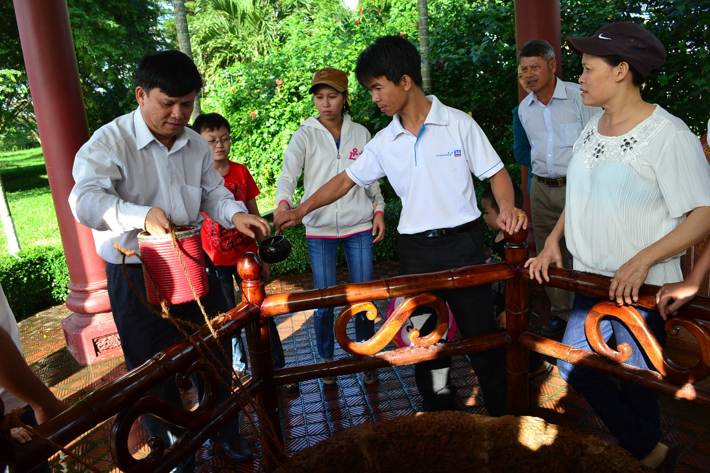 Du khách cùng nhau thưởng thức nước ngọt được múc lên từ giếng nước mà ba anh em nhà Tây Sơn từng uống.