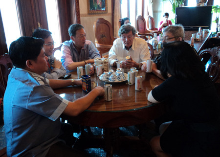 Ông Trần Văn Trí (trái) làm việc với các đối tác đưa nước uống collagen sang Pháp và Canada, trưa 8-5. Ảnh: Sáu Nghệ