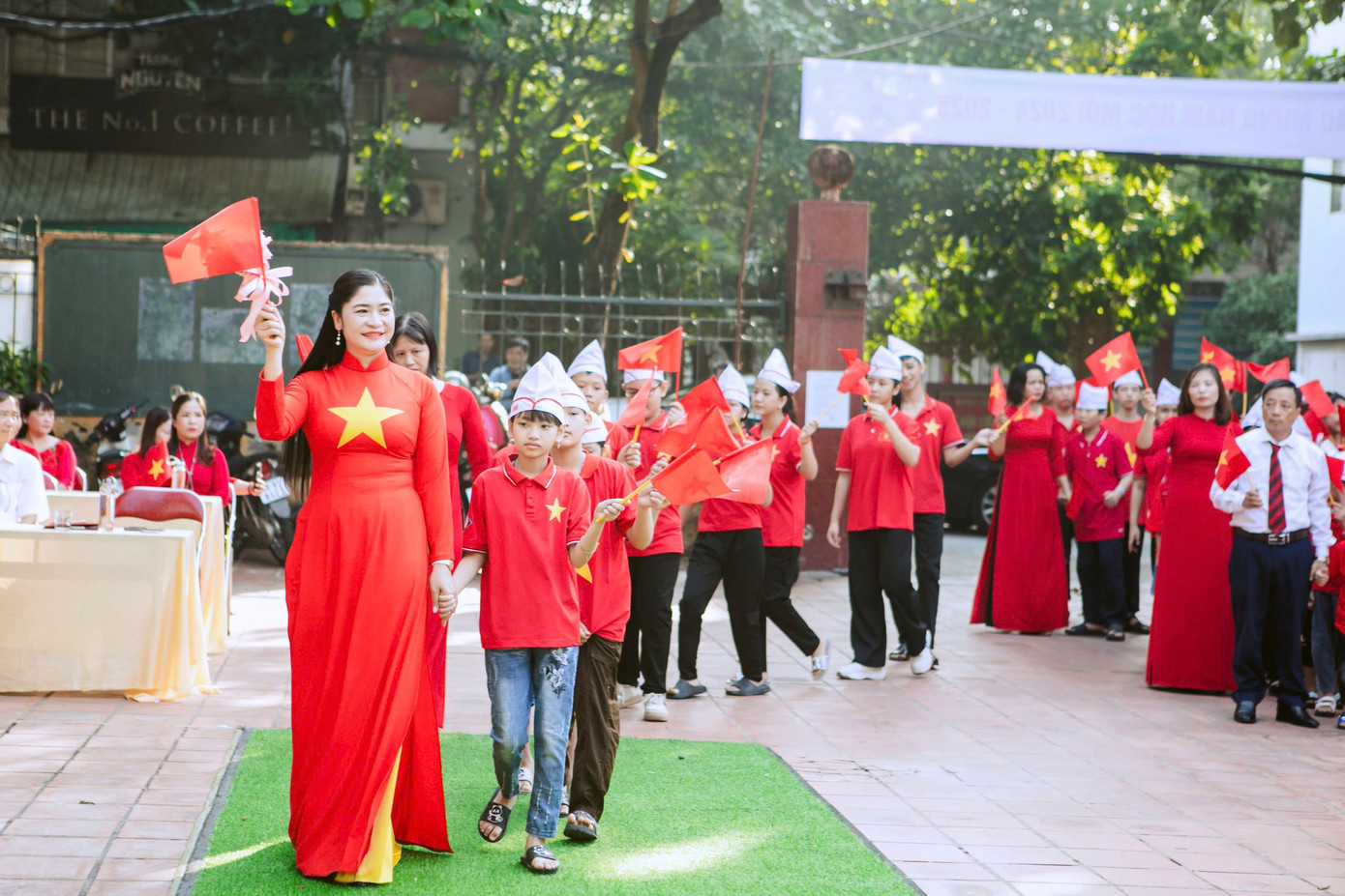 Cô Nguyễn Thị Nghĩa - Giám đốc Trung tâm dắt tay các em lớp 1 bước vào khai giảng dưới sự chào đón hân hoan của các em học sinh lớp 2,3,4,5 và các thầy cô giáo.