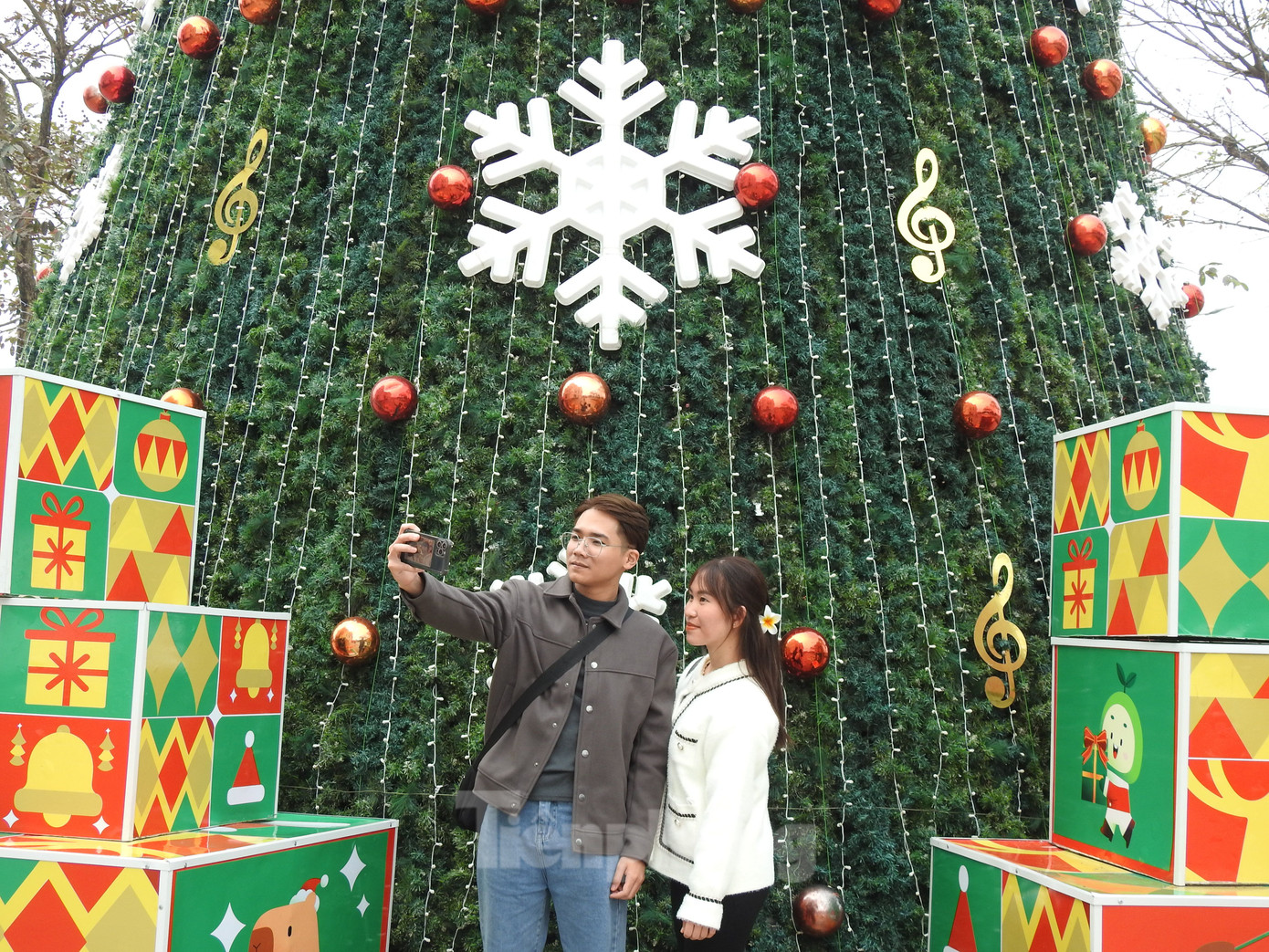 Đôi bạn trẻ cùng nhau ghi lại bức hình đẹp mùa Noel.