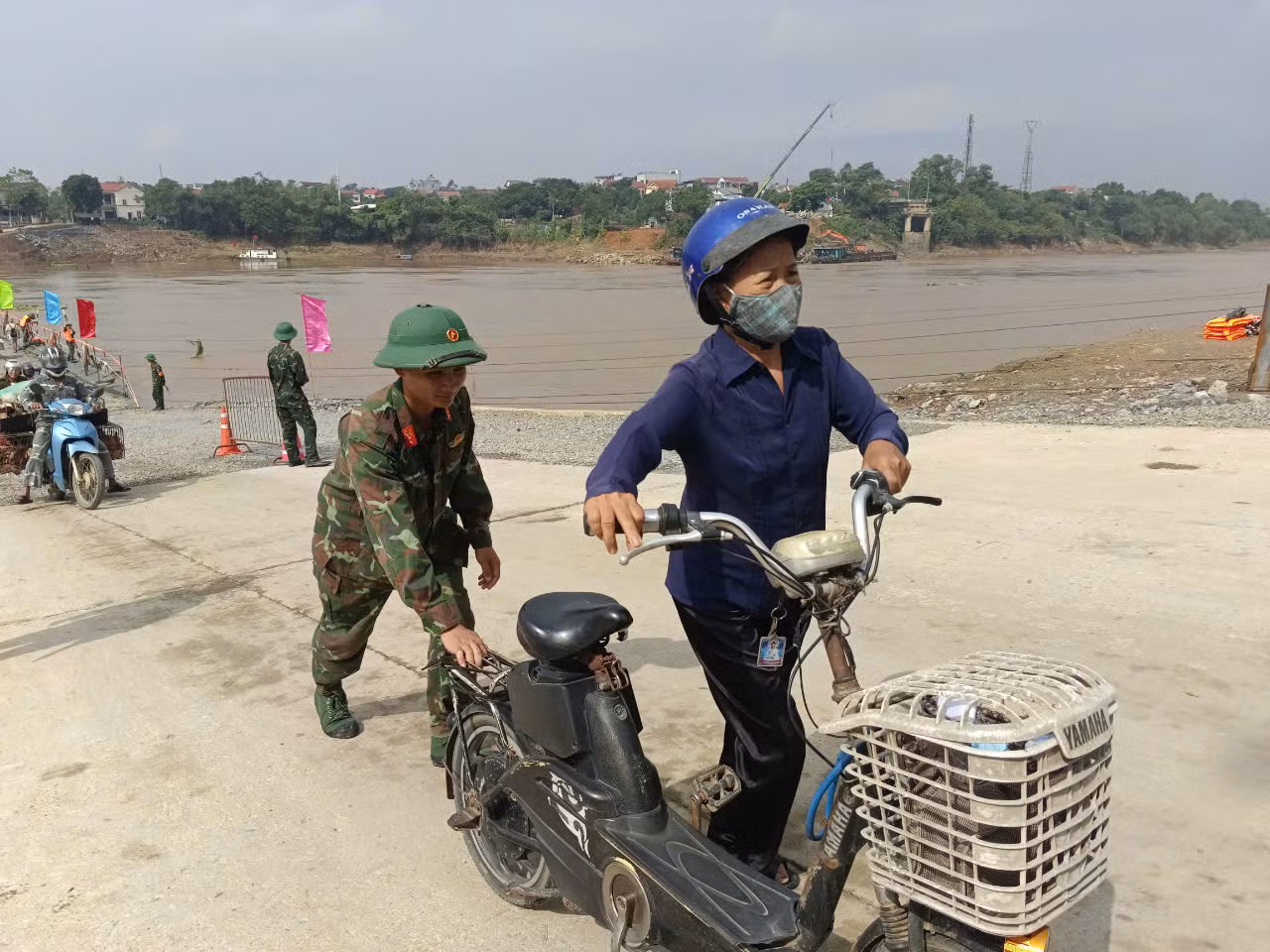 Bộ đội đẩy xe giúp người dân qua cầu.