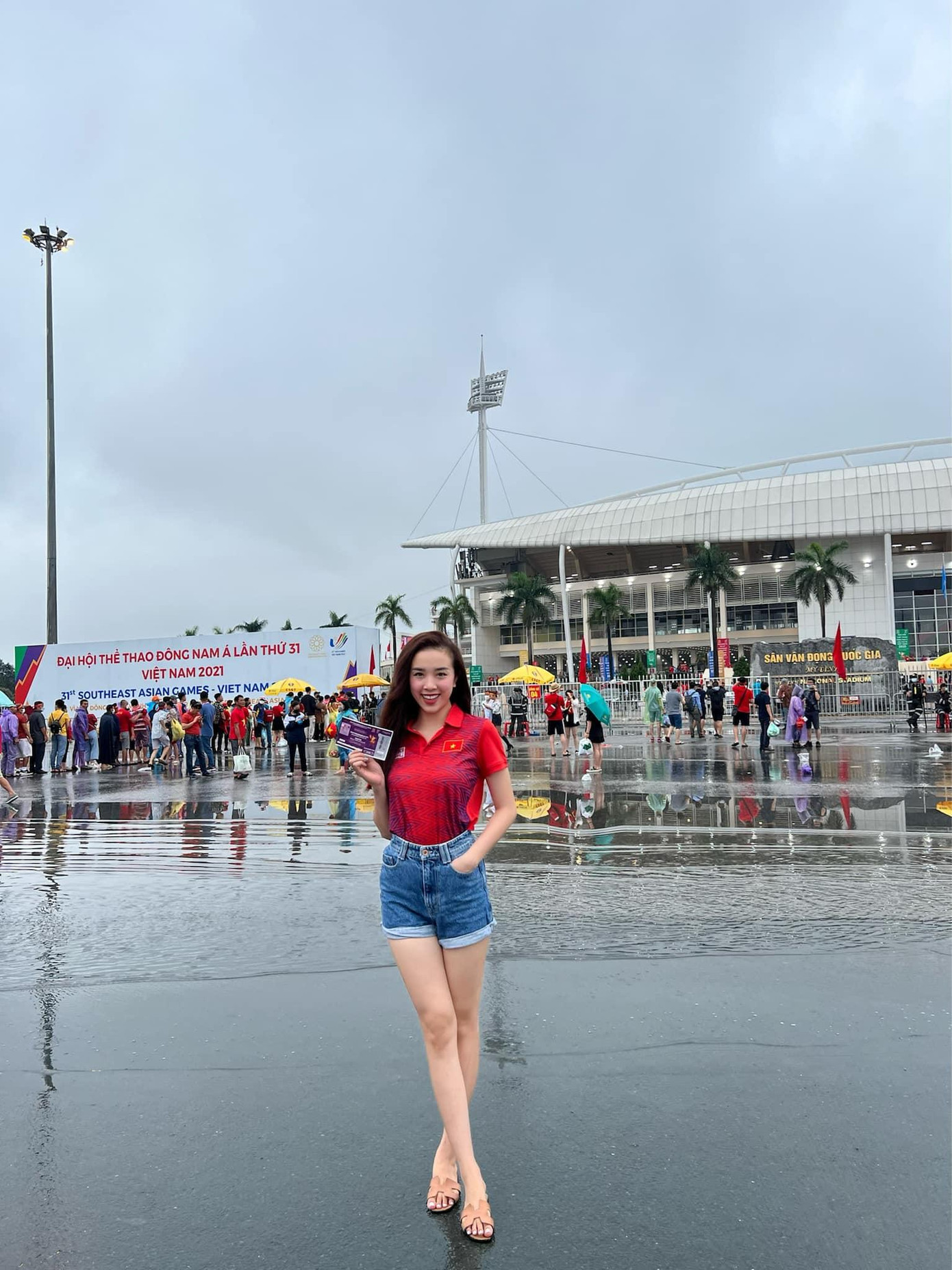 Người đẹp diện quần short khoe chân dài và mặc áo đấu màu đỏ rực với cờ đỏ sao vàng trên ngực áo.