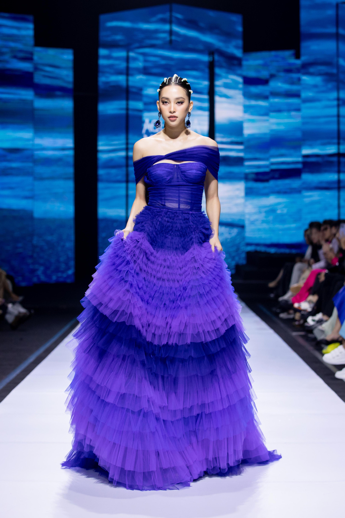 Hoa hậu Tiểu Vy đảm nhận vai trò vedette trong show diễn. Cô sải bước đầy kiêu sa với bộ váy xếp ly màu tím.