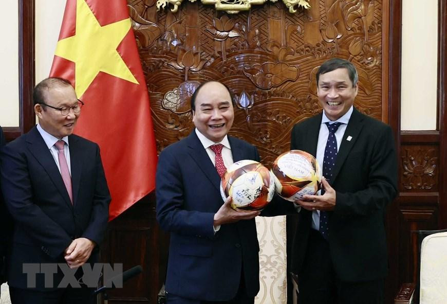 Chủ tịch nước Nguyễn Xuân Phúc và 2 huấn luyện viên. (Ảnh: Thống Nhất/TTXVN).