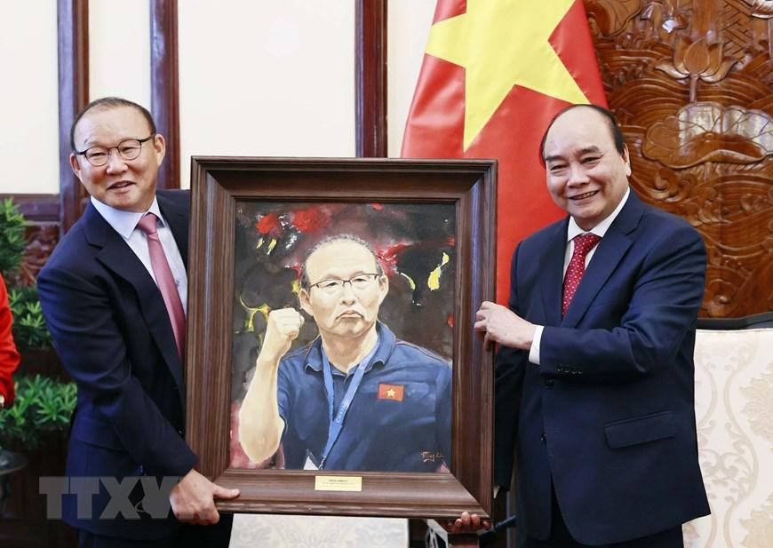 Chủ tịch nước Nguyễn Xuân Phúc tặng quà lưu niệm cho huấn luyện viên Park Hang Seo. (Ảnh: Thống Nhất/TTXVN)