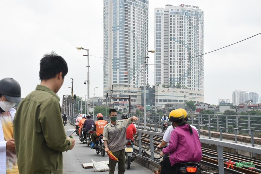 Hiện trường đã được đậy tạm bằng tấm bê tông và có nhân viên điều tiết giao thông trên cầu.