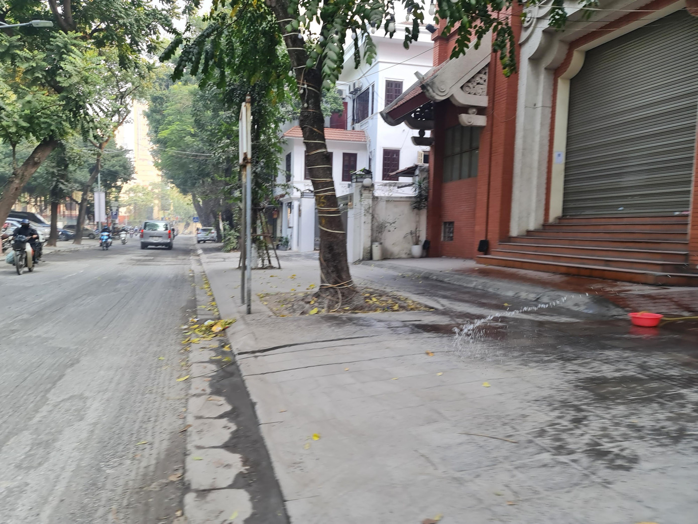 Người dân phải phun nước ra đường chống bụi nhưng cũng chỉ giảm được phần nào.