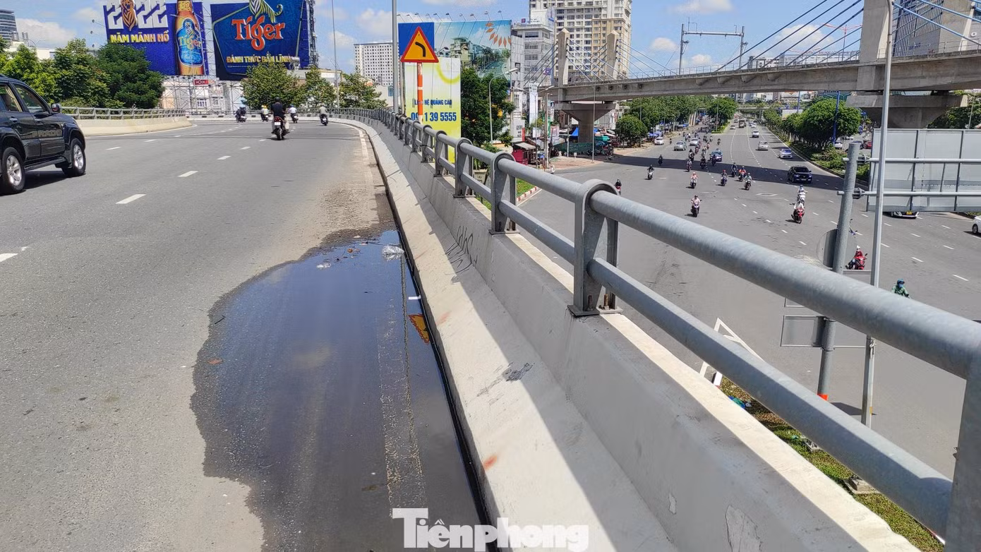 Miệng cống bị tắc nghẽn khiến nước mưa không thể thoát được và đọng thành vũng trên cầu vượt Nguyễn Hữu Cảnh.