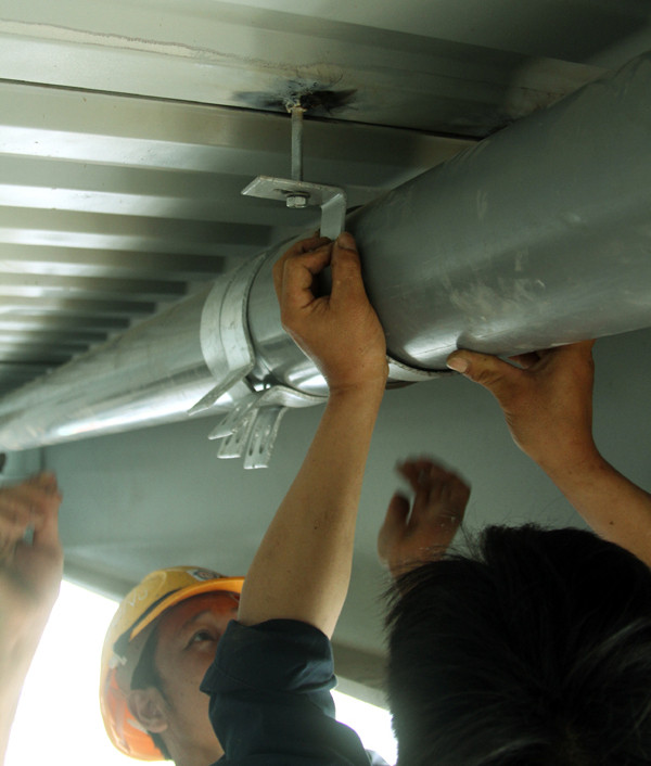 Các công nhân lắp dặt đường ống thoát nước dưới gầm cầu